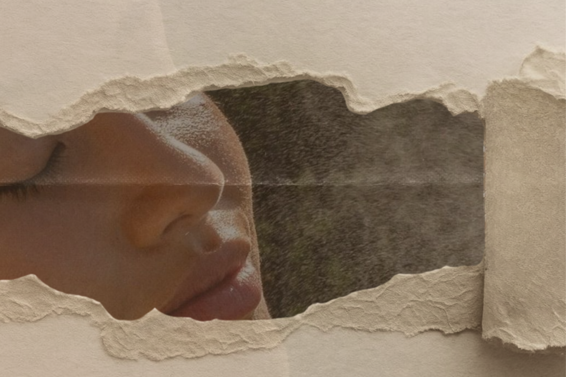 female face under ripped paper