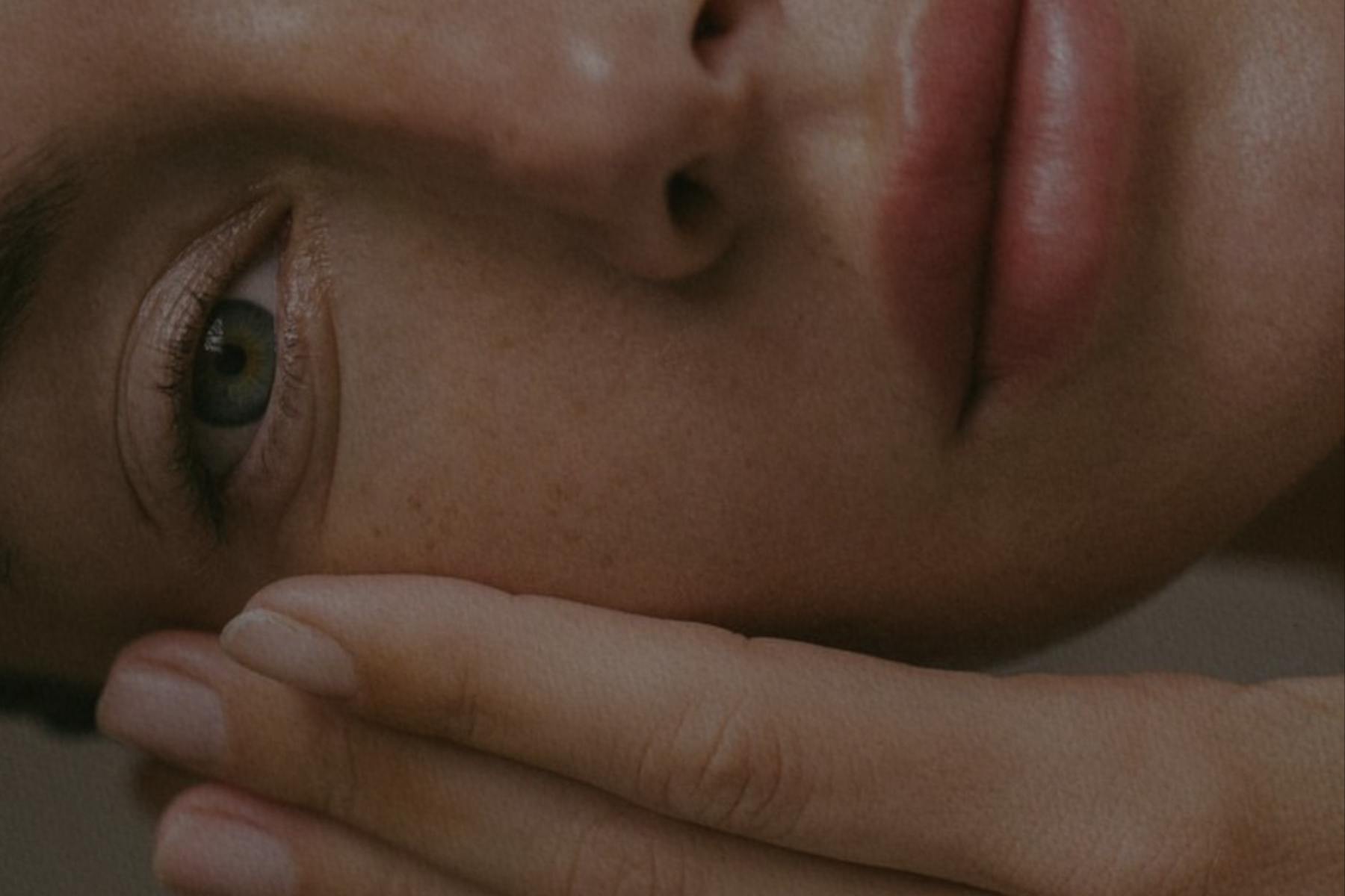 a woman's face and hand, rotated 90 degrees