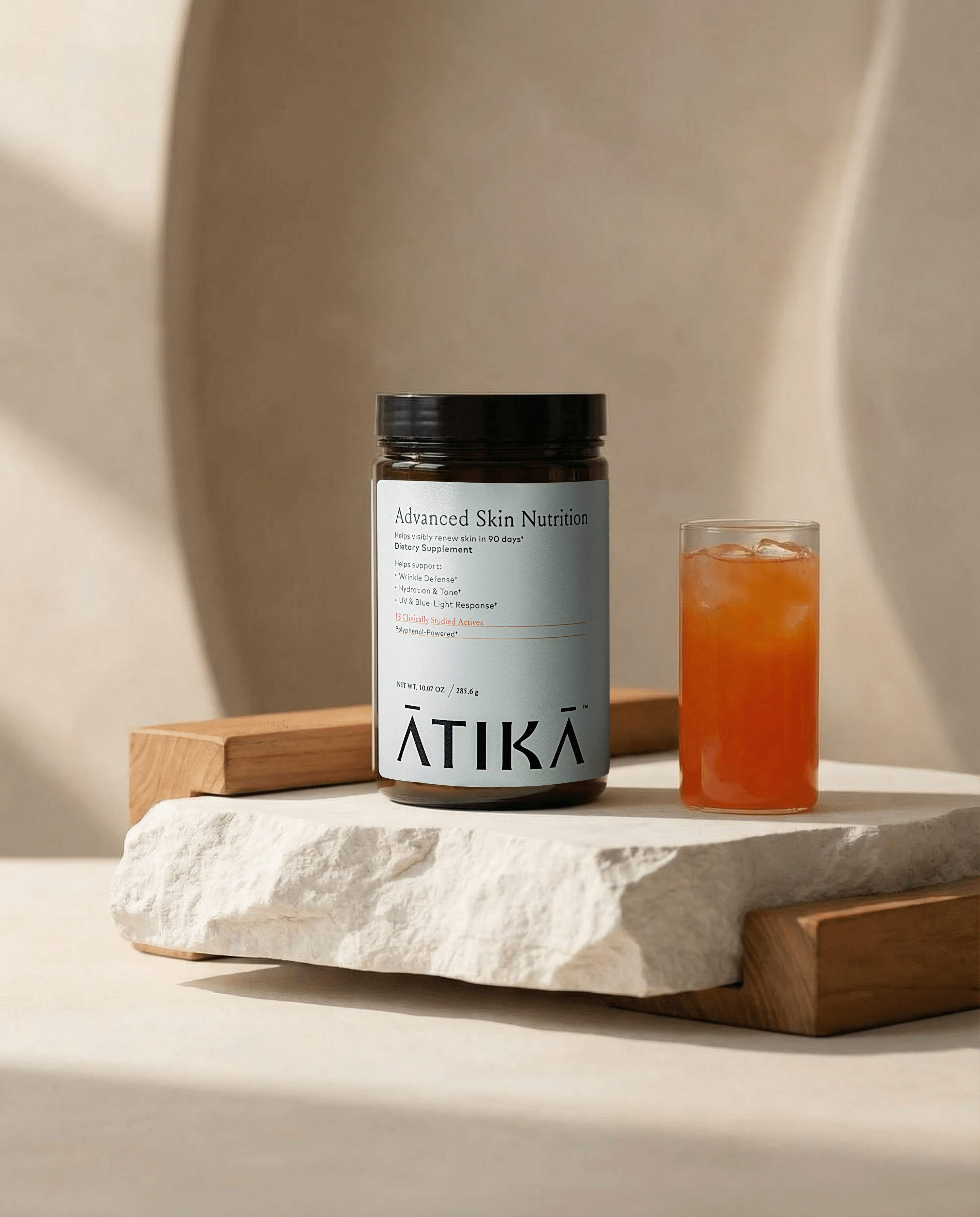 atika jar on white stone slab with glass with orange atika drink next to it