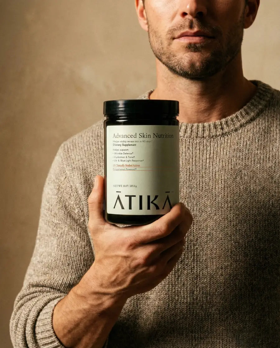 Man holding a supplement container labeled 'ATIKA' against a neutral background