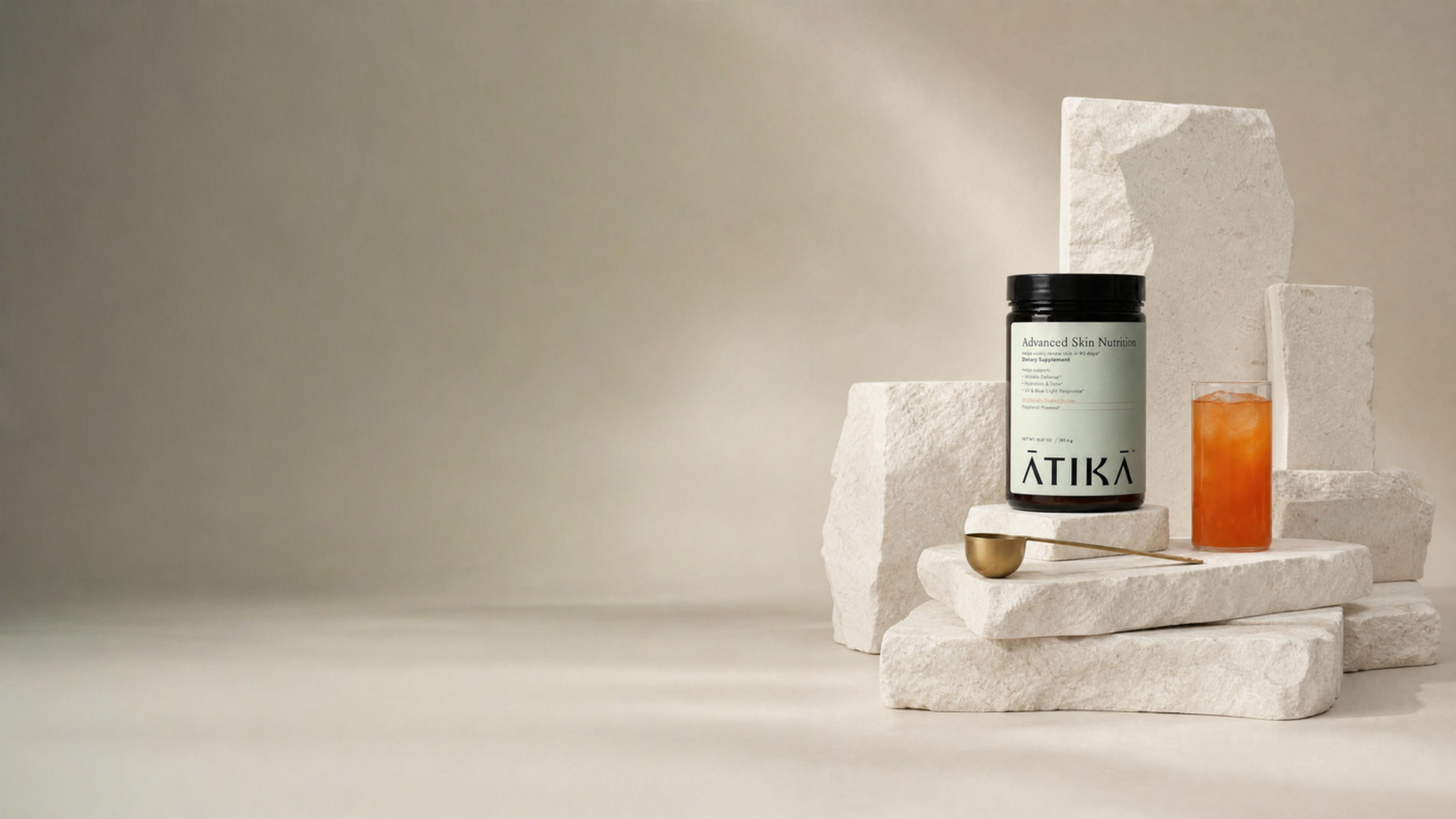 ATIKA advanced skin nutrition jar, glass and scoop on editorially assembled stone